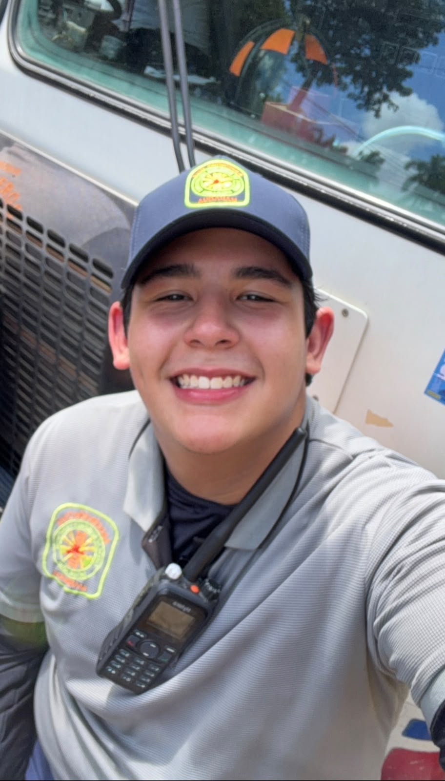 Juan in his volunteer firefighter uniform beside a fire vehicle