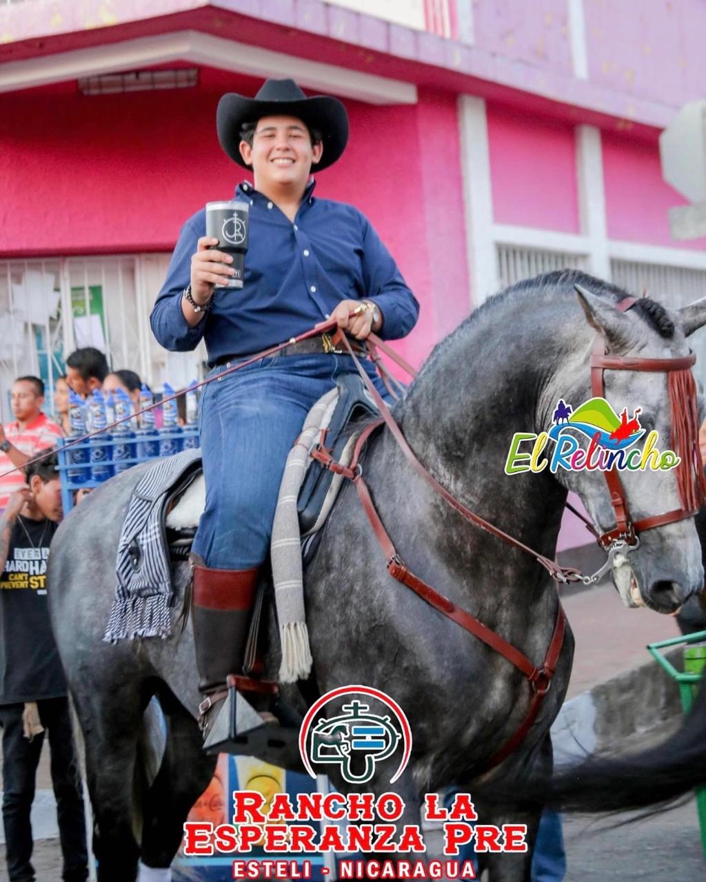 Juan riding a gray horse at an equestrian gathering
