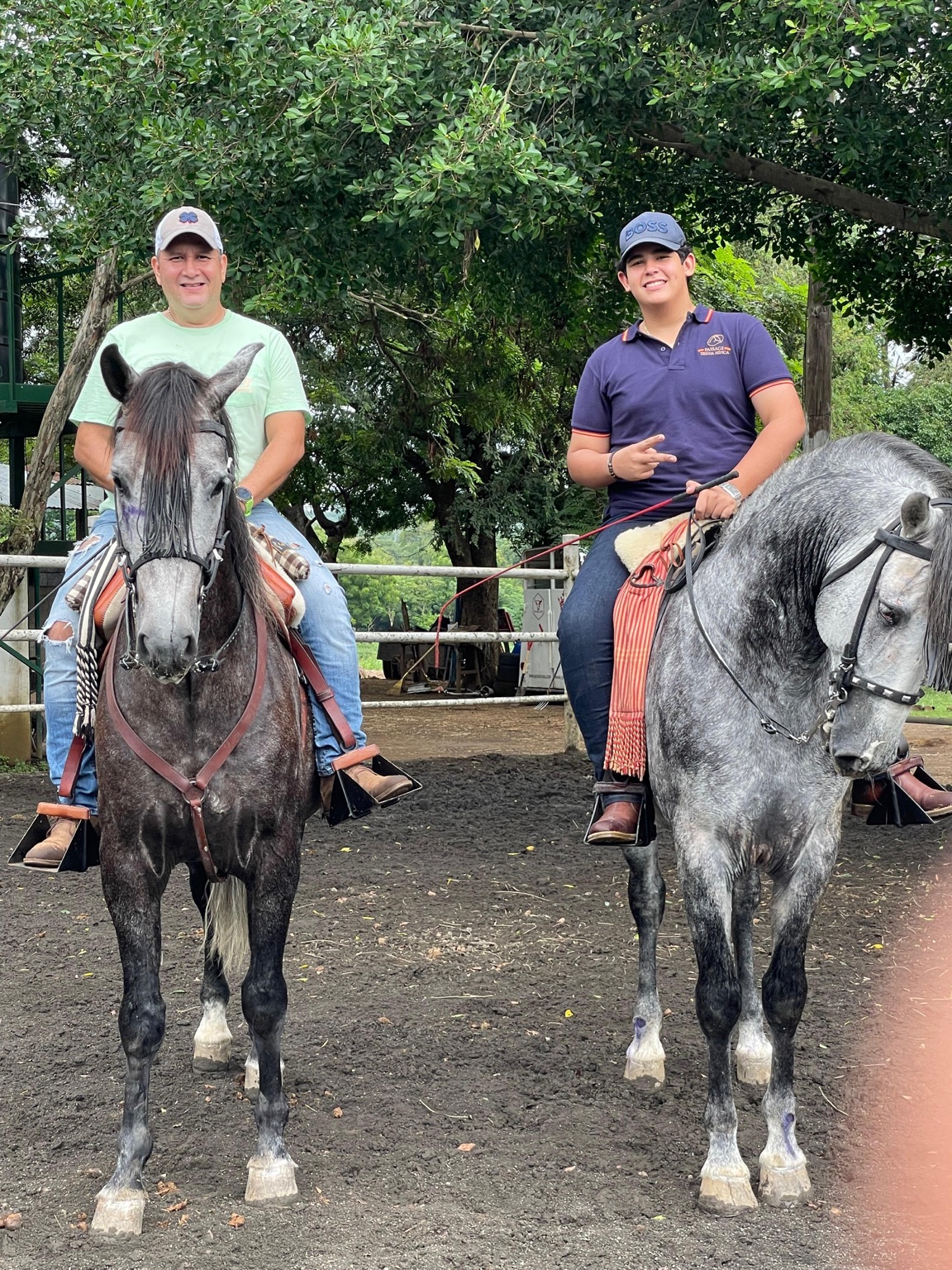 Juan and another rider on two gray horses at a riding arena